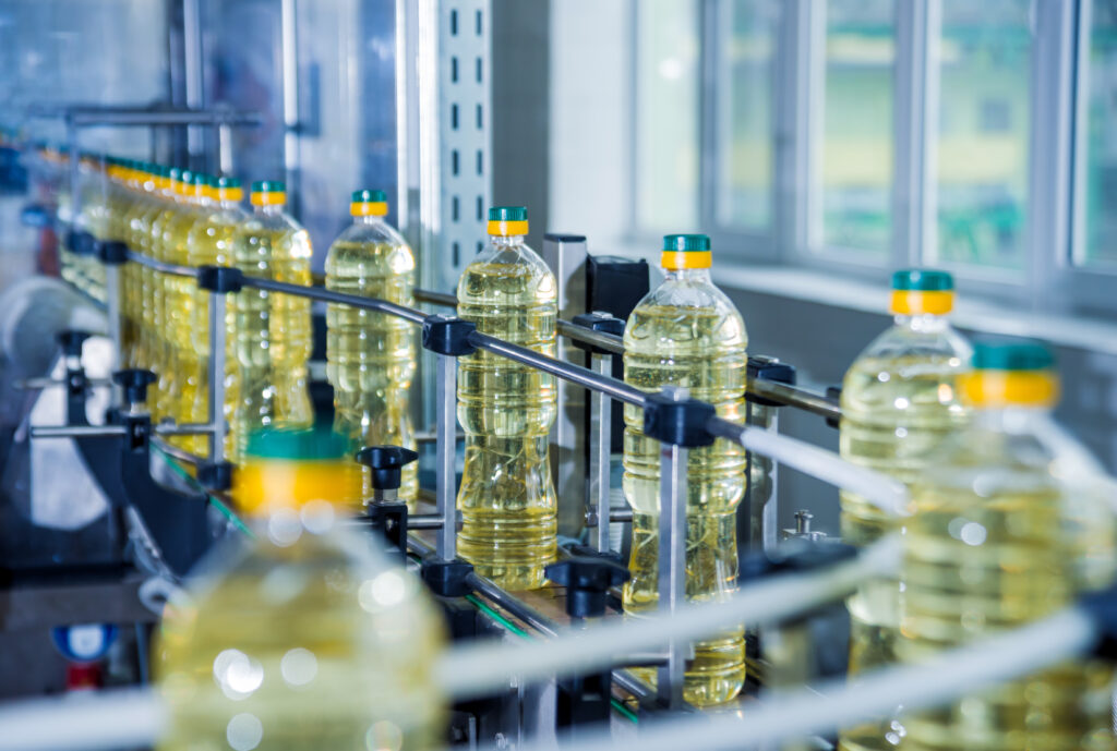 Bottling line of sunflower oil in bottles. Vegetable oil production plant. High technology. Industrial background